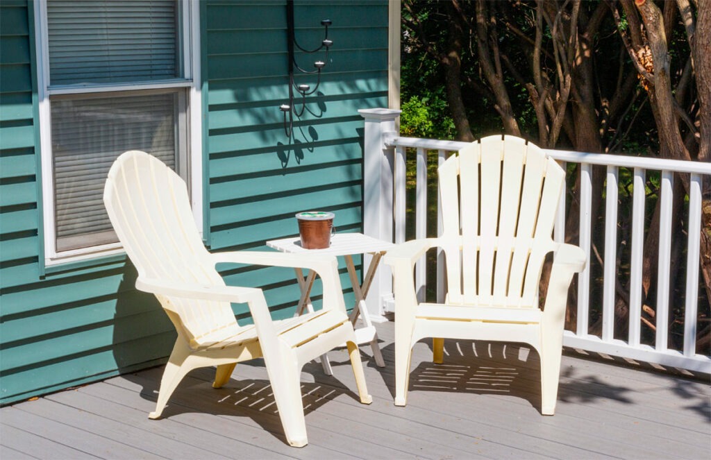 Zwei Gartenstühle aus Kunststoff stehen auf der Veranda